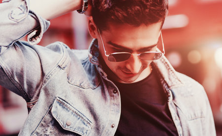 fashionable handsome man in denim jacket and glasses. lifestyle portraitの写真素材