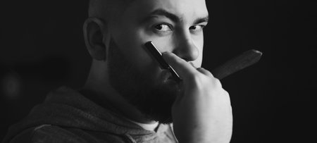 brutal man with a dangerous razor in barbershopの写真素材