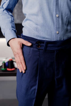 Tailor man working in his tailor shop. the master of tailoring in the workshop outlines the cutting linesの写真素材