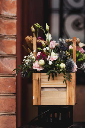 beautiful fresh flowers in a wooden pot in the street. outdoor plantsの写真素材