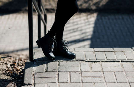 Female legs in short skirt and black pantyhose in park. women's tightsの写真素材