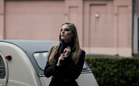 Elegant stylish lady with long hair in coat posing in city street. fashion woman