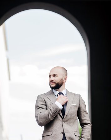 a successful man in a suit straightens his tie. Positive IT manager or businessmanの写真素材