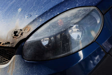 Car hood with a hole from rust and corrosion on blue carの写真素材