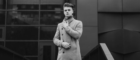 elegant man in an autumn coat and a watch on the street. stylish guyの写真素材