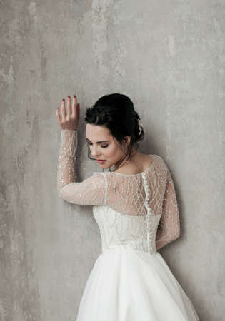 Bride in wedding dress near wall. elegant beautiful woman in fashion styleの写真素材