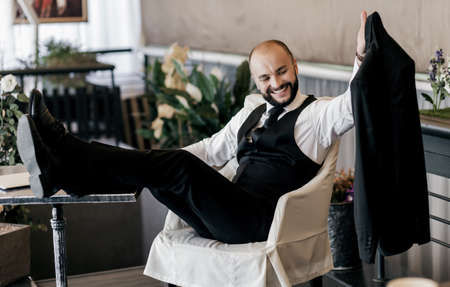 smiling handsome bearded man holding a jacket in his hands. happy businessman in suitの写真素材
