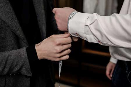 tailors hand taking client's measurements in atelier. fashion designerの写真素材