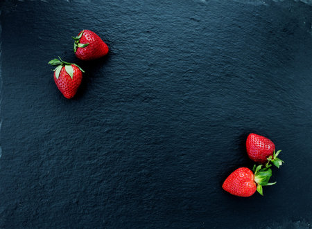 Summer still life with fresh juicy strawberries on slate background. Fruit diet concept, Top view...