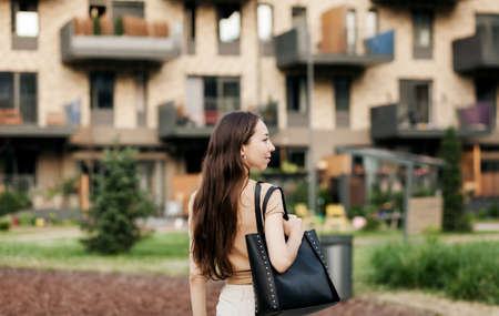 Attractive young woman posing with black handbag on city streets. Stylish modern and feminine image, styleの写真素材