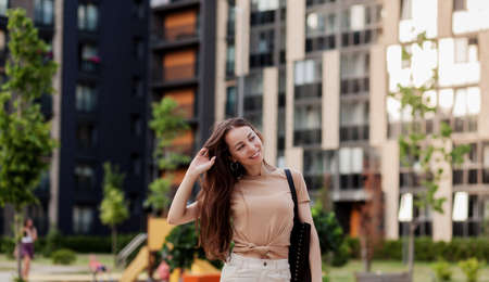 Attractive young woman posing with black handbag on city streets. Stylish modern and feminine image, styleの写真素材