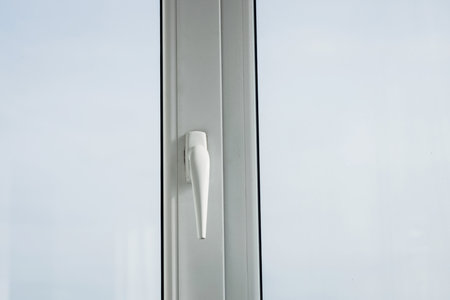 Female window cleaner cleaning glass windows on modern building high in the air on a lift platform.の写真素材