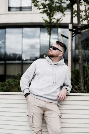 bearded man in gray blank hoodie. mockup for print. urban settingの写真素材