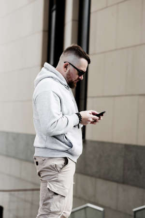 bearded man in gray blank hoodie. mockup for print. urban settingの写真素材