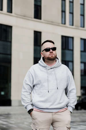 bearded man in gray blank hoodie. mockup for print. urban settingの写真素材