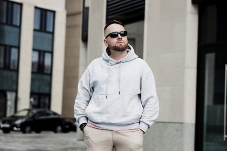 Stylish man texting on phone. Casual urban professional entrepreneur using smartphone. Outdoor portrait of bearded guy with mobile in the streetの写真素材