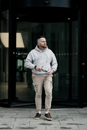 handsome hipster man in sunglasses with beard wearing gray blank hoodie or sweatshirtの写真素材