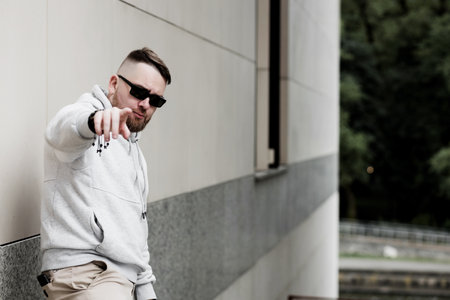 Vaping man holding a mod. A cloud of vapor. Stylish bearded guy with vape.の写真素材