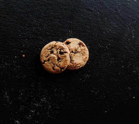 Homemade stacked chocolate chip cookies on black slate backgroundの写真素材