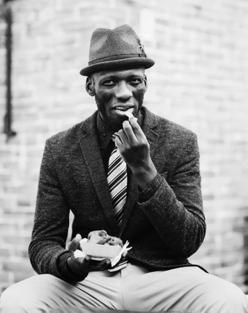 happy young black african man with near bricks buildingの写真素材