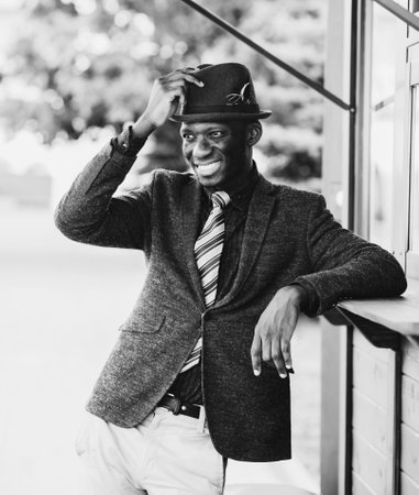 smiling cheerful african american man in suit and hatの写真素材