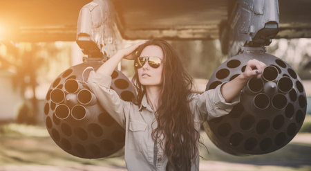 Portrait of young beautiful woman in sunglasses pilot in front of airplane.の写真素材