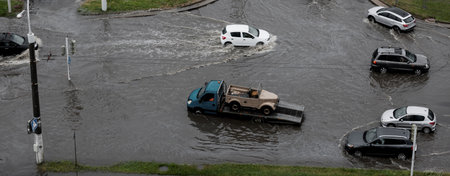 Minsk, Belarus, August 2022 - Cars are driving on a road flooded with heavy splashes of rainwater. climate changeのeditorial素材