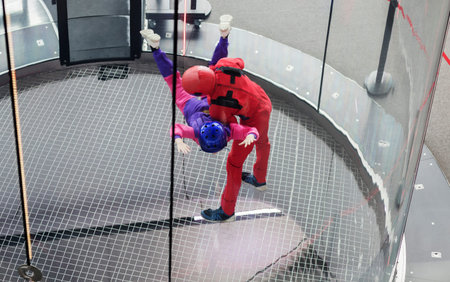 instructor training a sportsman paratrooper in aerodynamic aero tube