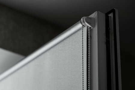 Gray roll blinds placed on a windowsの写真素材