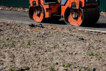 Laying of new modern asphalt. Asphalt laying equipment works on the site.