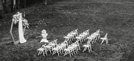 Wedding arch decorated with flowers outdoors. Beautiful wedding set up. Wedding ceremony on green lawn in the garden.の写真素材