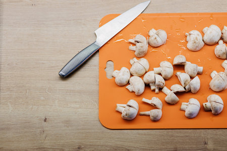 Peeled and washed mushrooms champignons during cooking. Fresh raw champignon on boardの写真素材