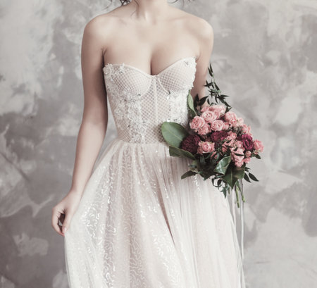 Wedding fashion bride in dress with bouquet in handsの写真素材