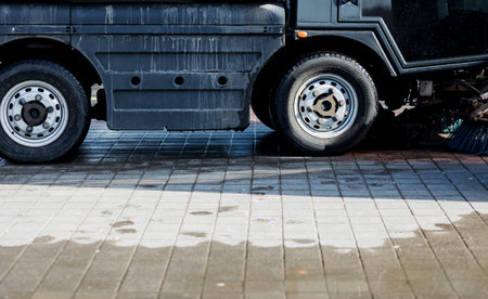 urban sweeper cleans road from dirt with a round brush. Street vehicle cleanerの写真素材