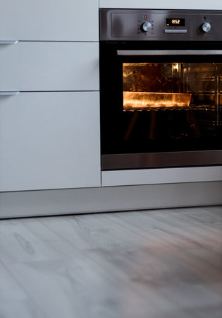 cooking in the built-in oven. modern kitchen with appliancesの写真素材