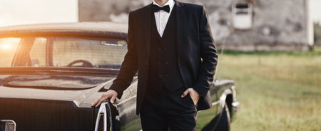 Confident wealthy elegant man in suit near classic carの写真素材
