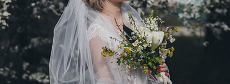 Stunning bride in a blooming garden enjoys the morning. girl in luxury dressの写真素材