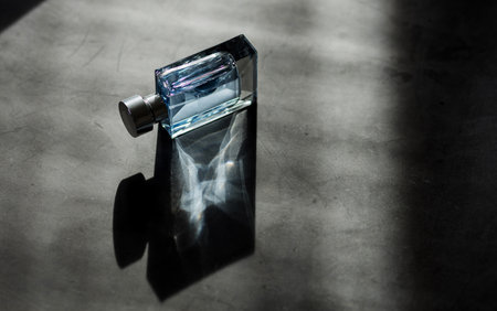 men perfume. bottle spray. Transparent bottle of perfume on dark backgroundの写真素材