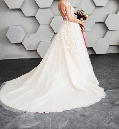 Beautiful bride in wedding dress with bouquet. studio interior.の写真素材