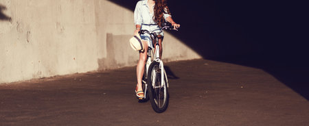 beautiful woman sitting on city bicycle. Outdoor lifestyle portrait of girl with city bikeの写真素材