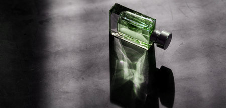 men perfume. bottle spray. Transparent bottle of perfume on dark backgroundの写真素材