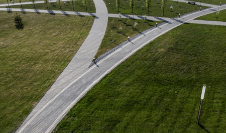 Curved garden path with fresh green cultivated lawn and trees. view from a height. landscaping of the siteの写真素材