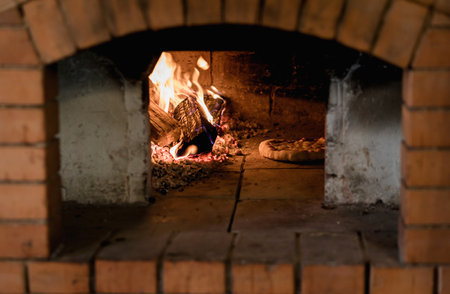 Pizza baking in the oven. Italian pizza is cooked in a wood-fired ovenの写真素材