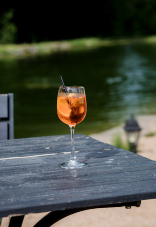 glass of orange spritz aperol drink cocktail on table outdoors sunset with blurred background.の写真素材