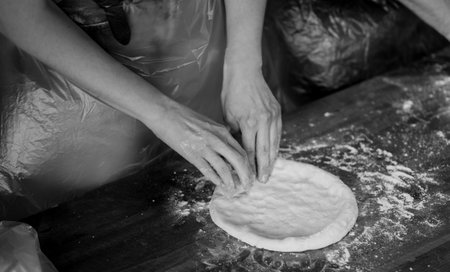 Processing of the pizza dough by the pizza maker. traditional italian foodの写真素材
