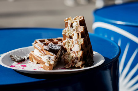 belgian waffles with cream and icing sugar on a plate. Tasty sweet sugar wafflesの写真素材