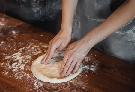 hands knead the dough for pizza making. Traditional Italian food. soft focus.の写真素材