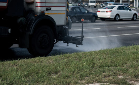 Street cleaning machine working in city. Sweeper cleaning the sidewalk with pressurized water.の写真素材