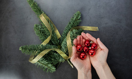 Hands holding balls on Christmas decorations background.