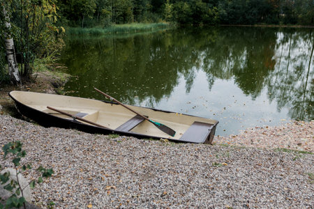 Old wooden boat with paddle on lakeの写真素材